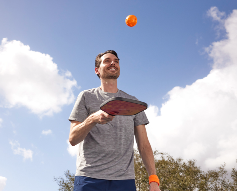 Man playing pickleball outside mobile